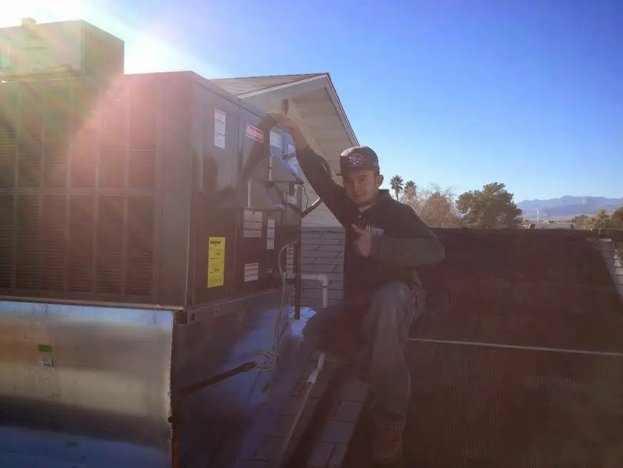 HVAC technician performing HVAC Inspection on a rooftop unit in Kingston